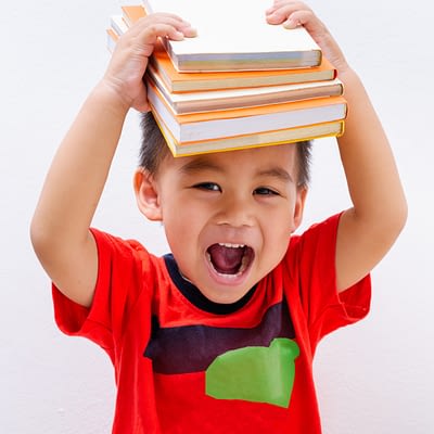 Back to school, cute student boy kid stack book balanced on head early education programs
